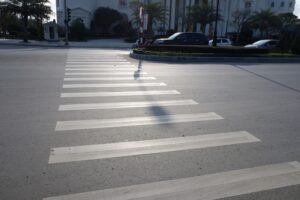 Crosswalk on the road for safety when people walking cross the street, Pedestrian crossing on a repaired asphalt road, Crosswalk on the street for safety, logistic import export and transport industry.